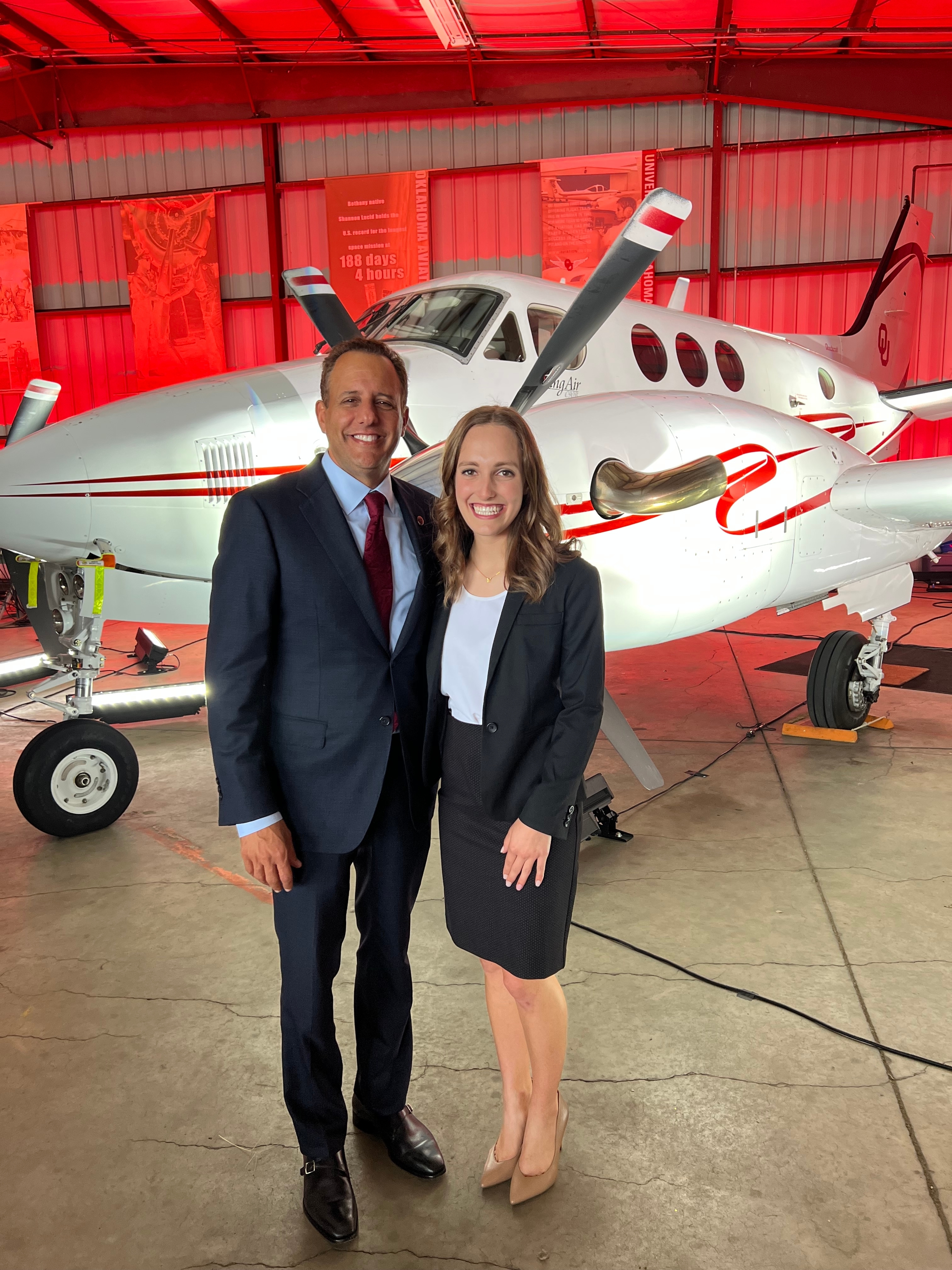 Lydia Koehler poses with OU President Joseph Harroz in front of the School of Aviation's King Air jet.