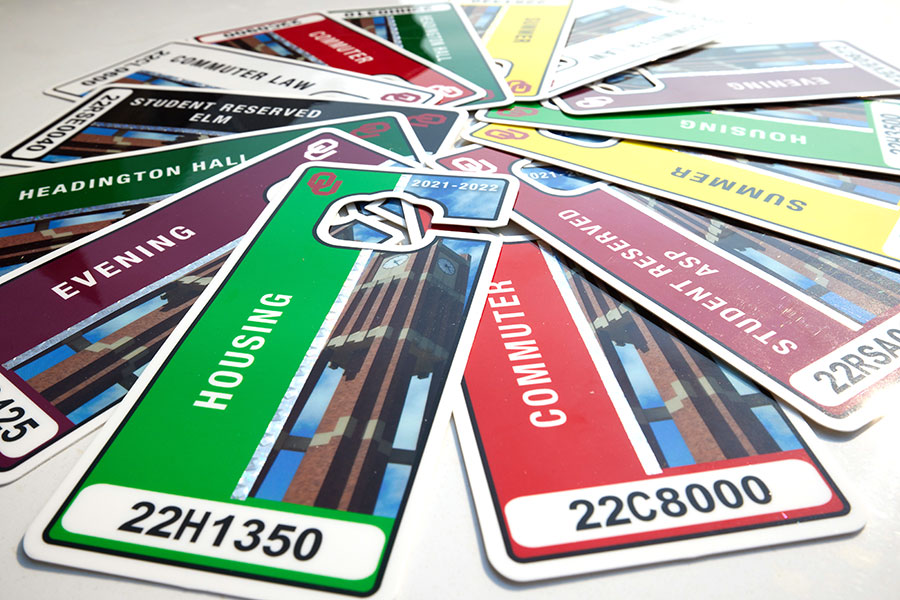 Several different parking permits in many colors, spread in a circle on a white table.