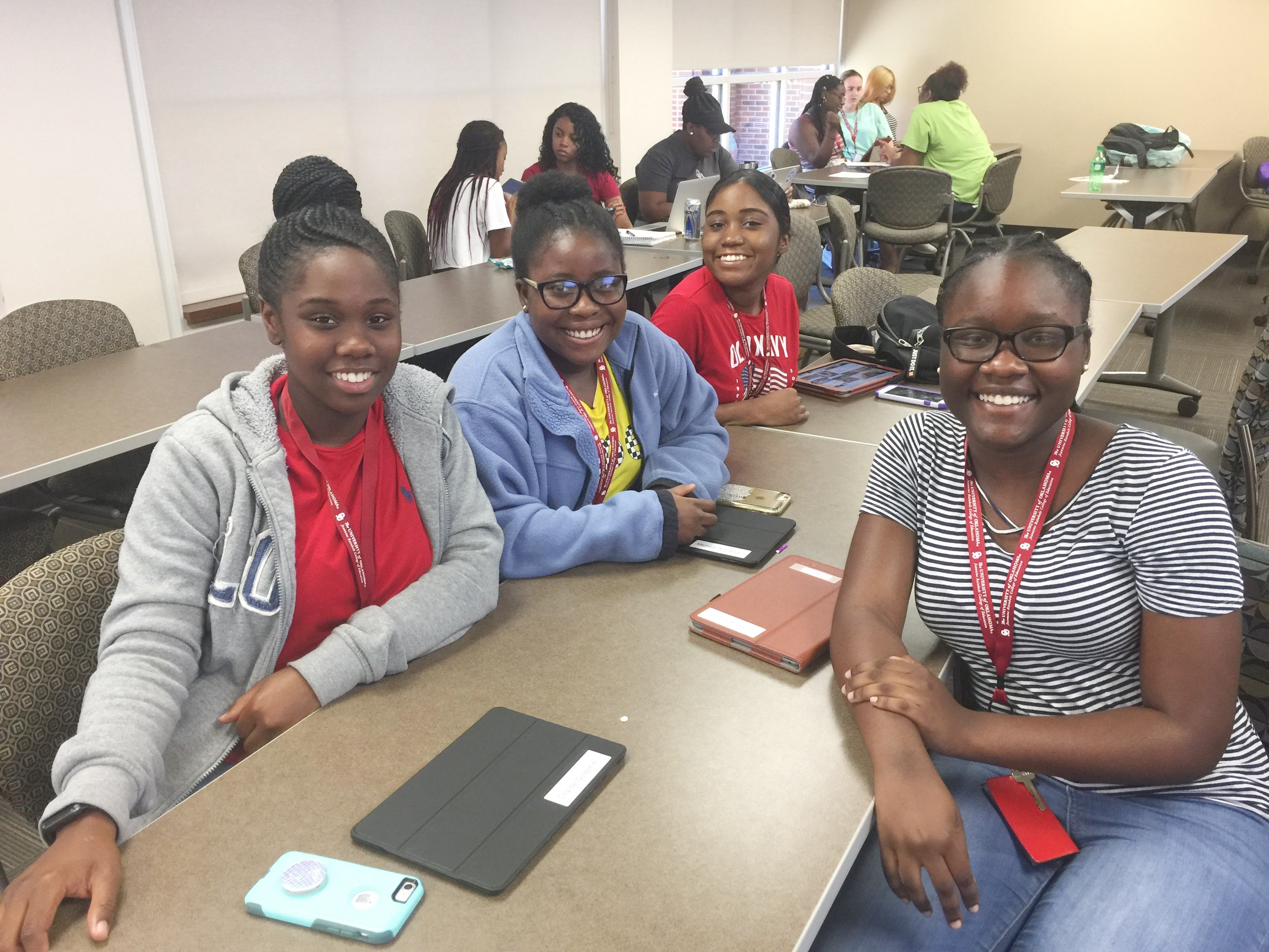Four students sitting at a desk in a classroom