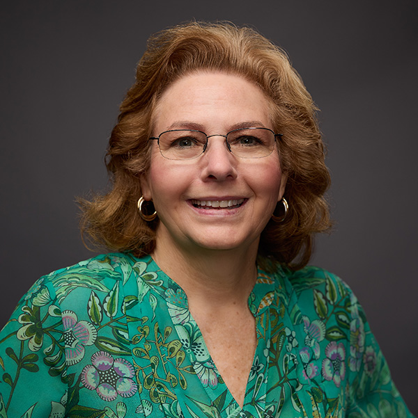 Sherry Cox in a green print top wearing glasses