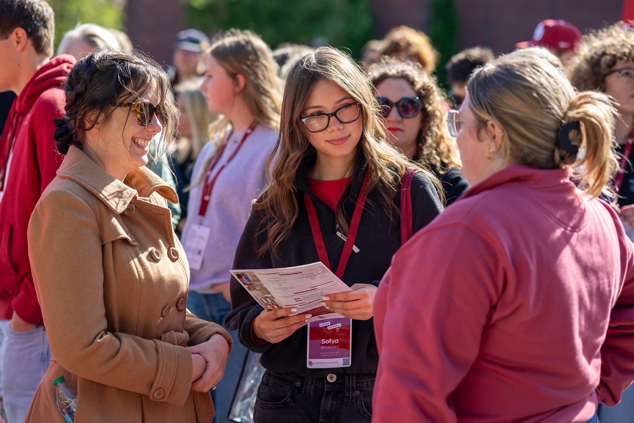 Student and their supporter connecting with OU staff at Sooner Saturday.