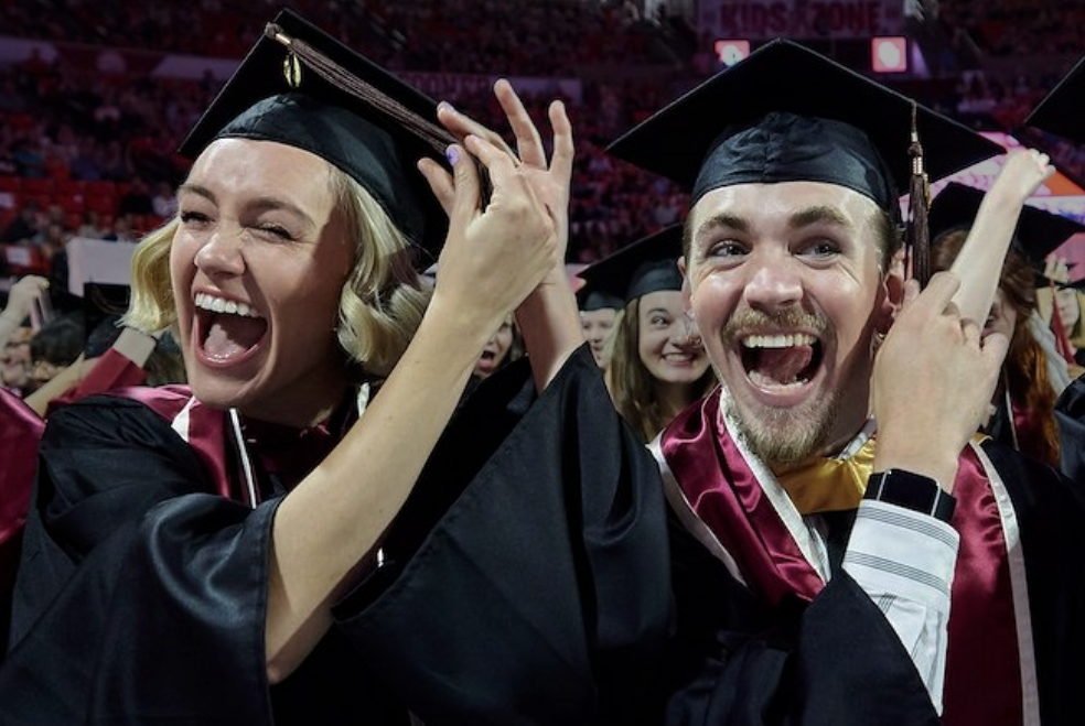 Students turning their ribbon on their graduation caps.