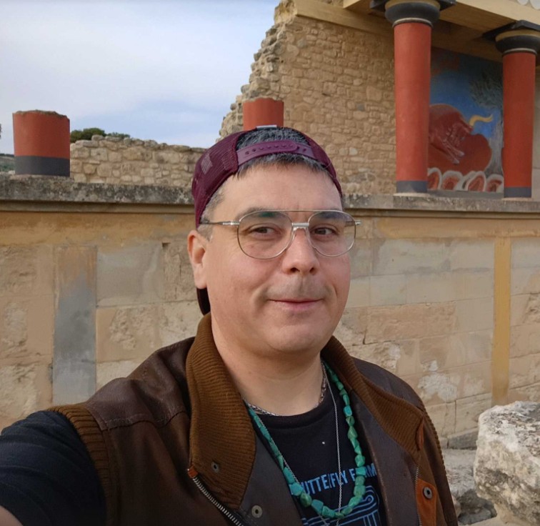 Headshot of Justin standing in front of ruins