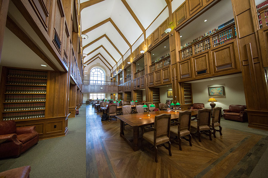 An empty library hall with desks and chairs in the center.