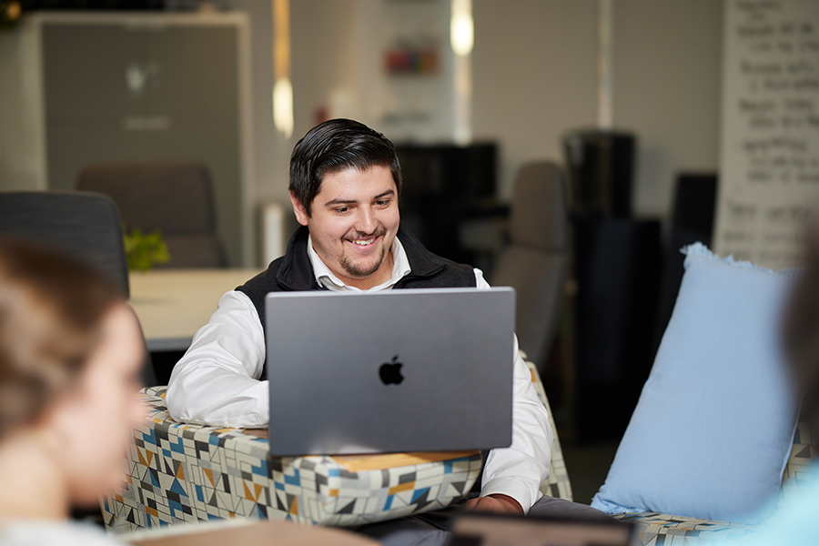 A man in the library working on a laptop.