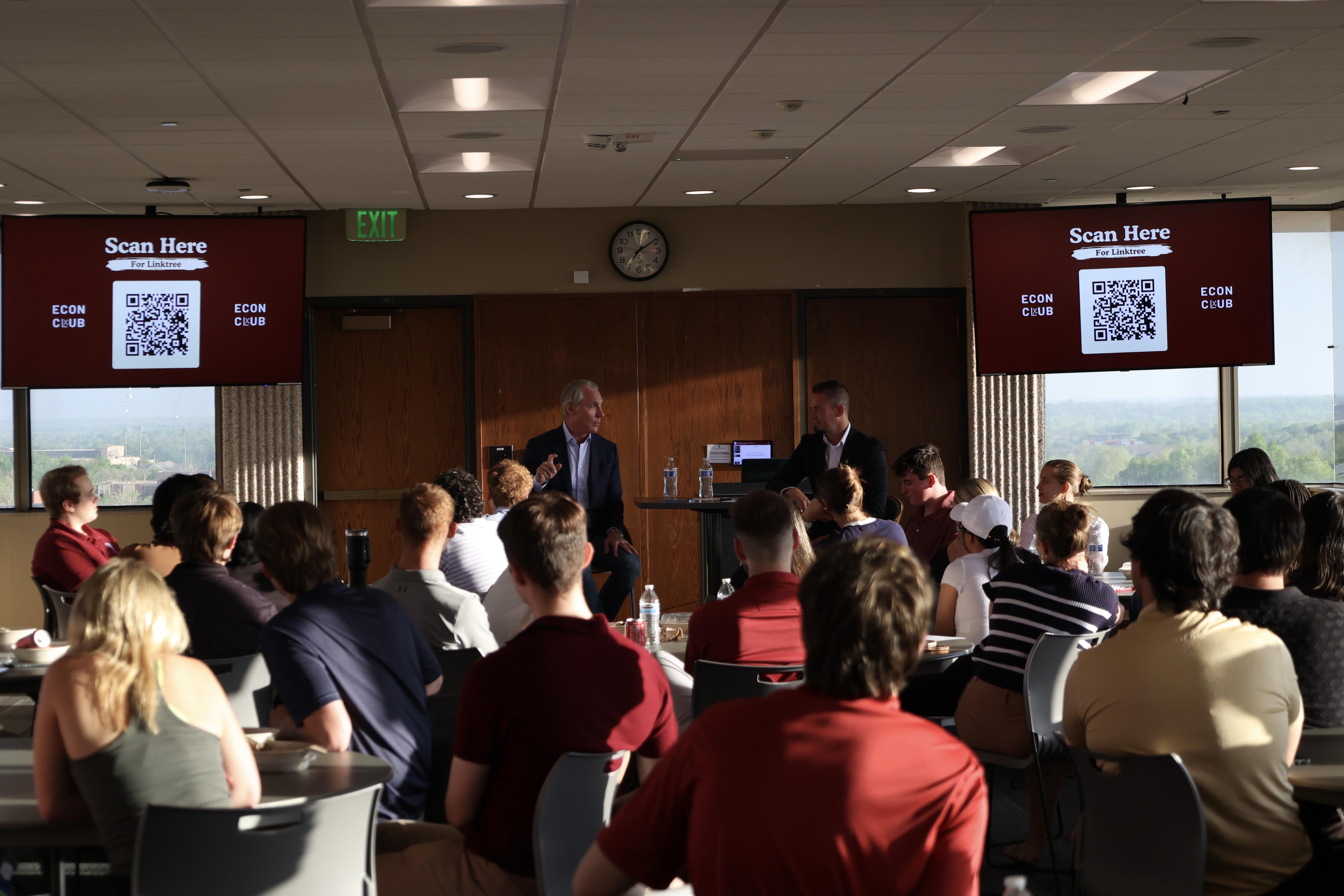 Dr. Miller speaking in front of the classroom while students listen. 
