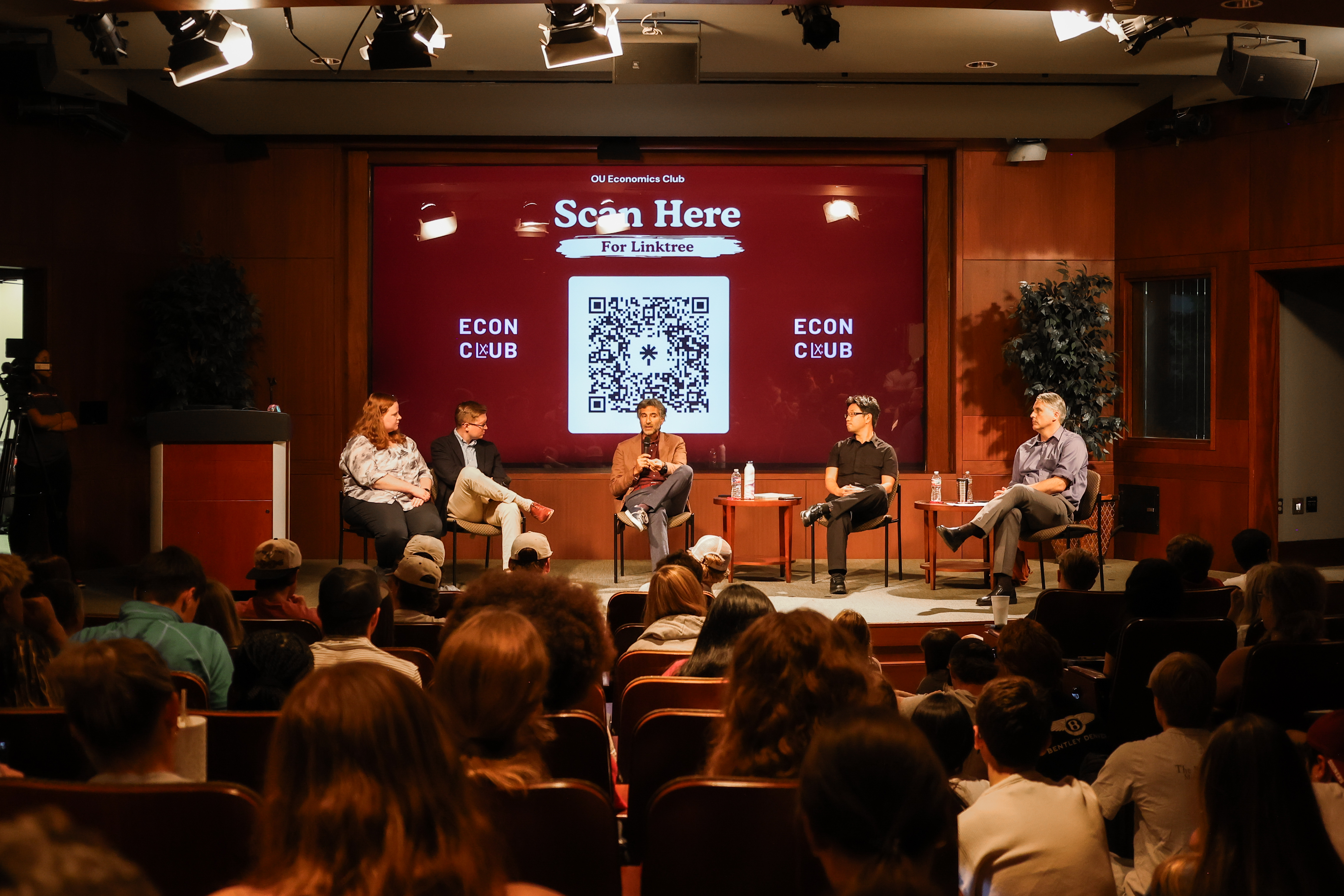 Econ club panelist speaking in front of crowd. 
