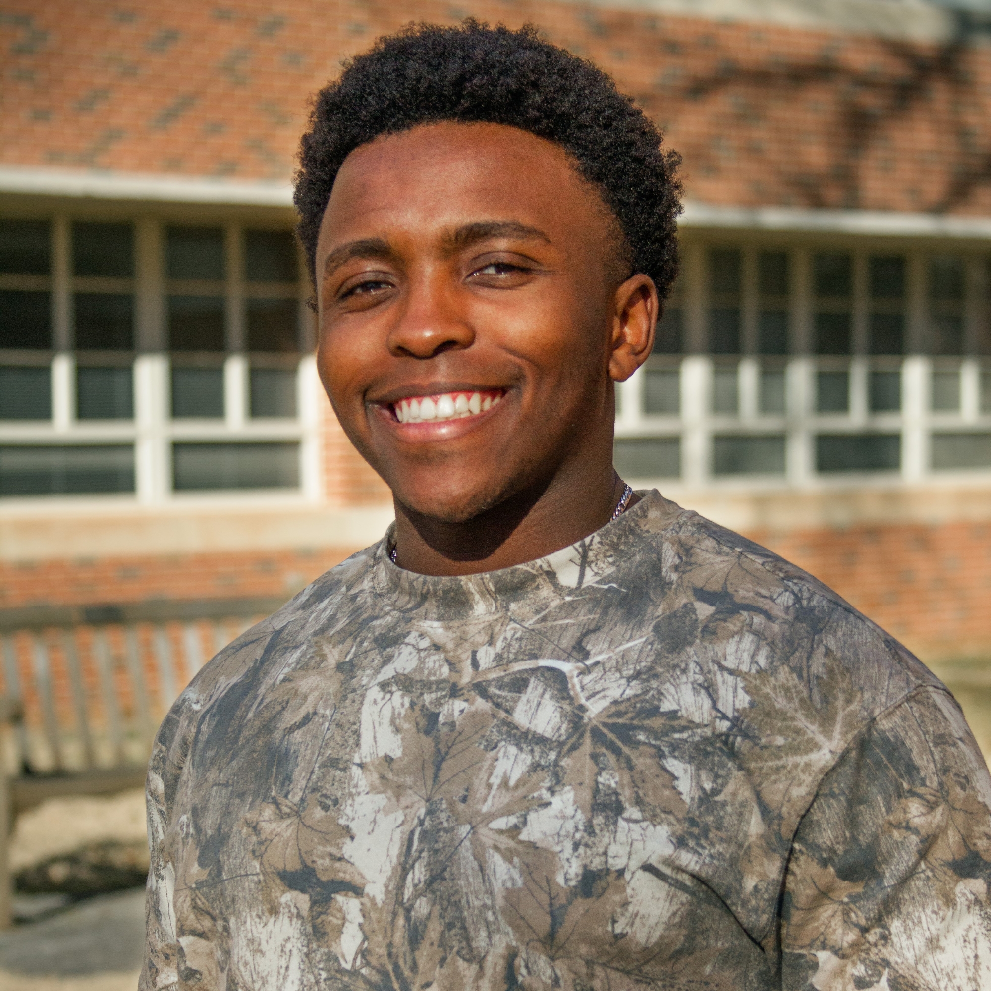 A person silhouette icon in white over a crimson background.