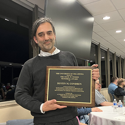 Dr. Condren holding the plaque for the Cecil W. Woods award.