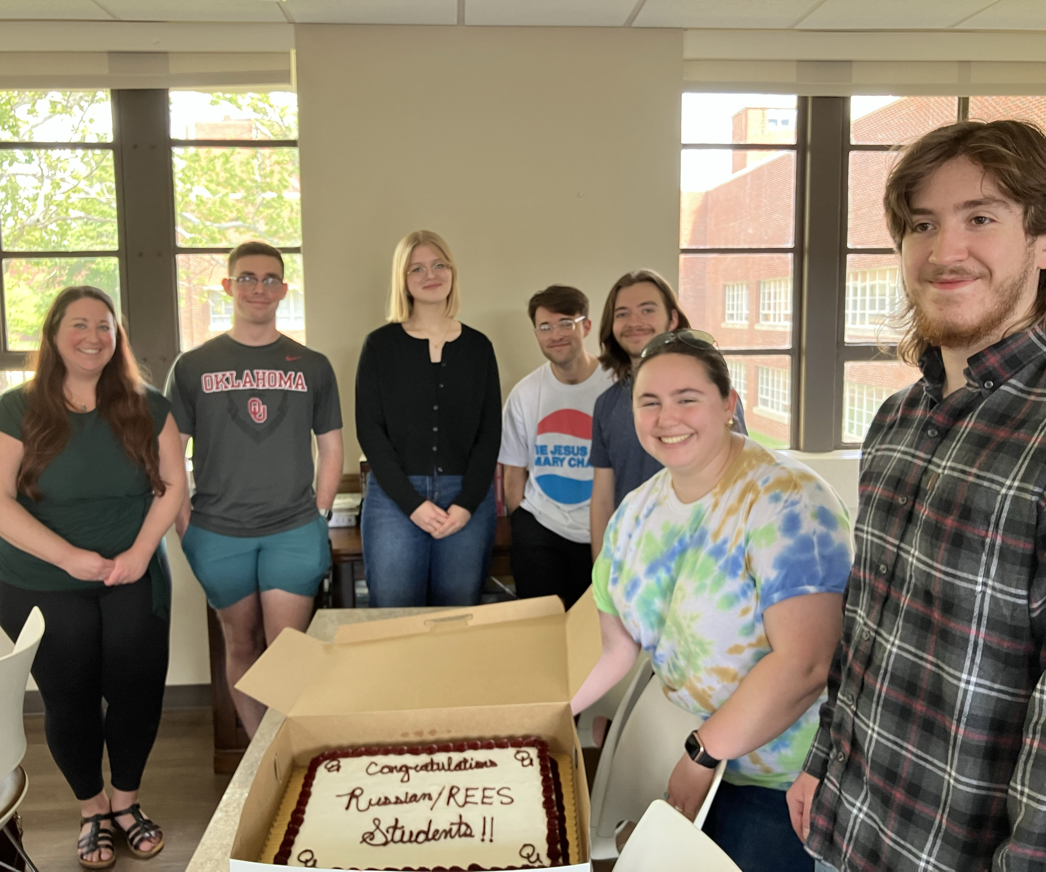 Russian students with a cake that reads "Congratulations Russian/REES Students".
