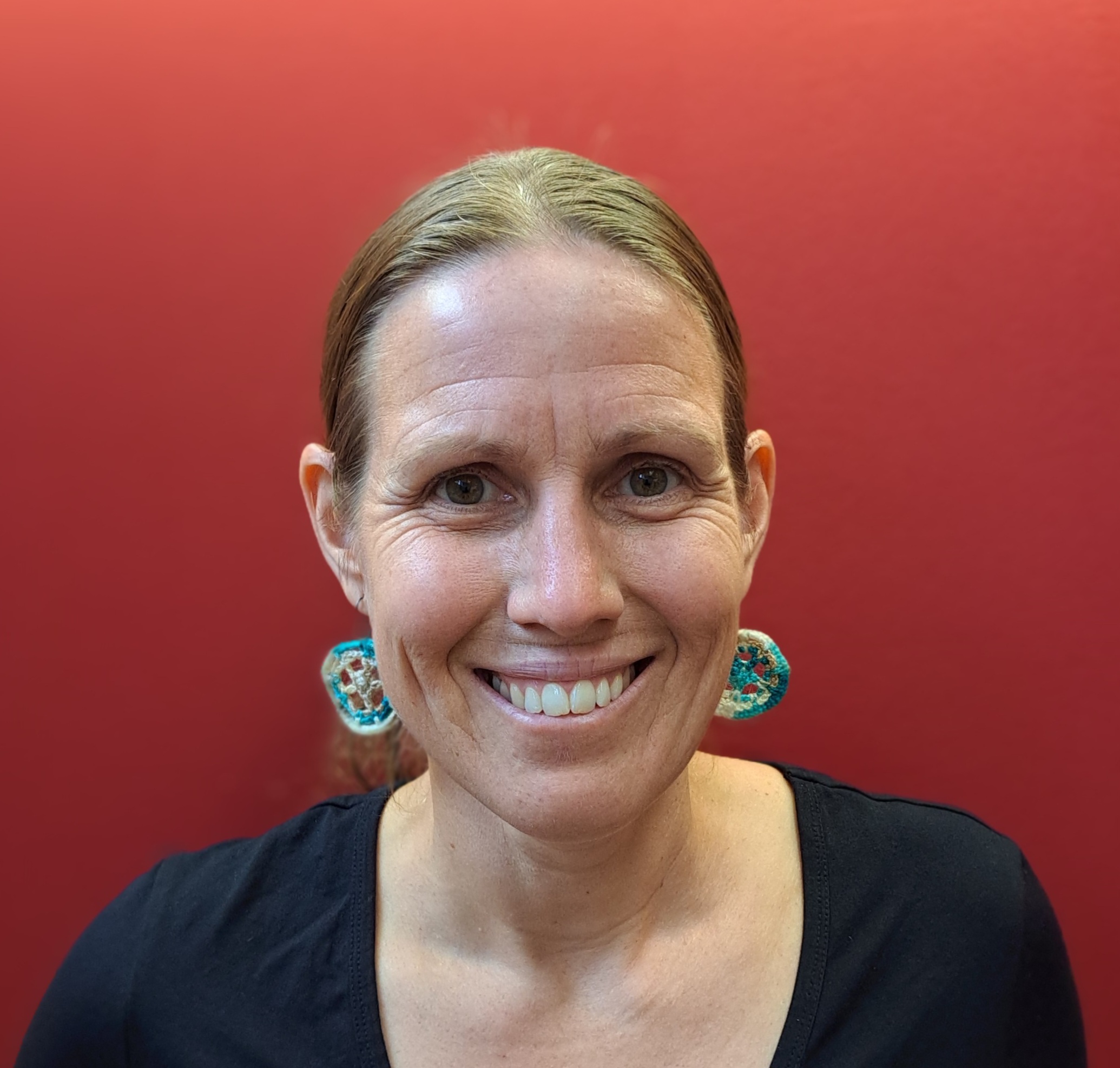 OU pole flag with flowering bush in background.