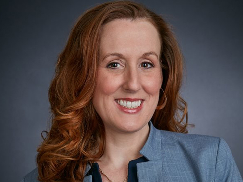 headshot of Jenn Doughty in a gray blazer
