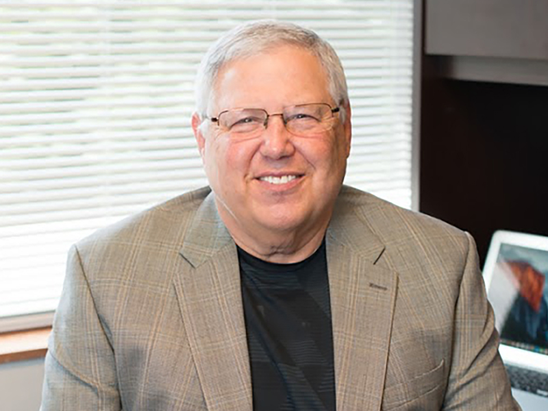 headshot of Gerald Gurney sitting at a desk in tan sportcoat