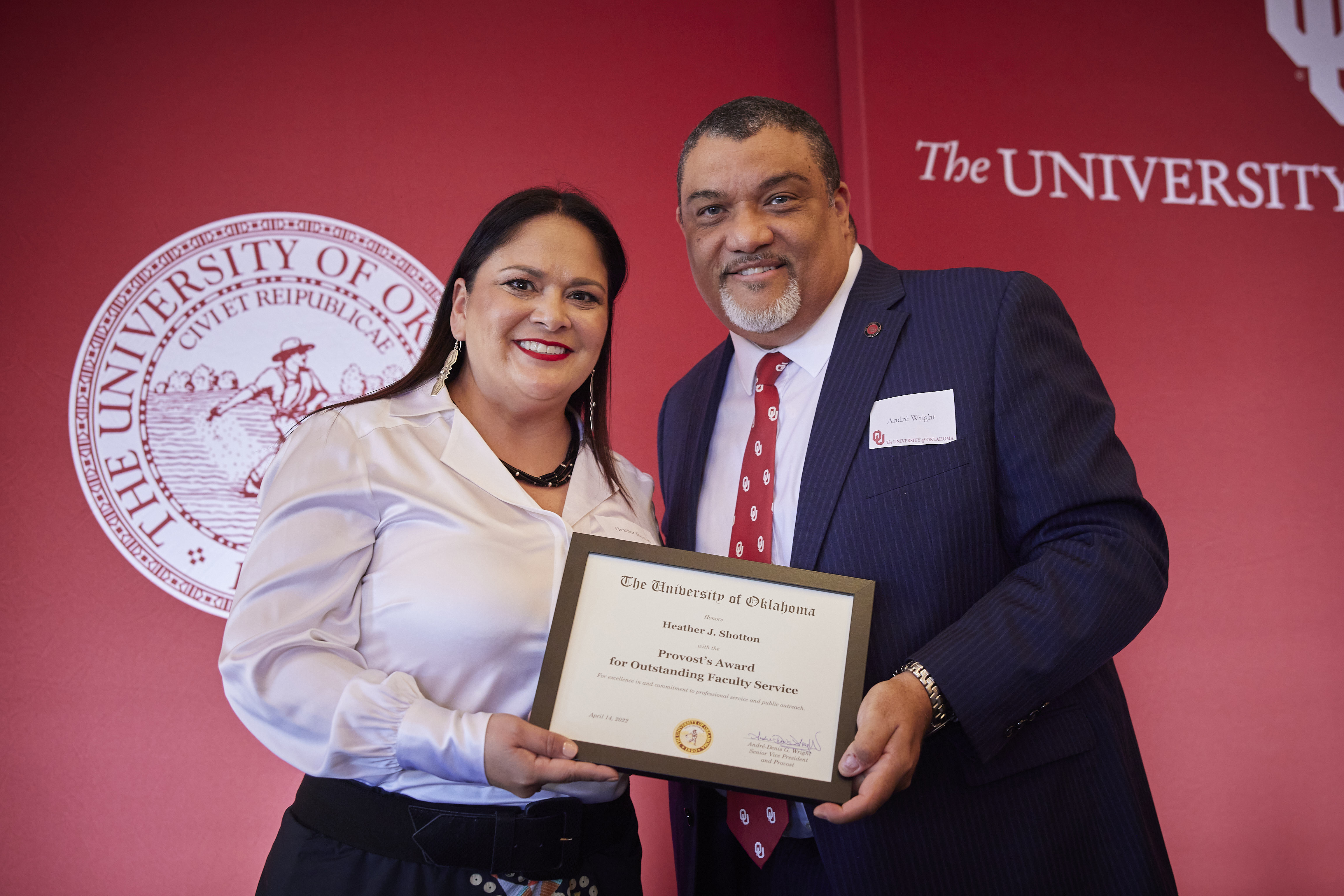 Heather standing with Provost Wright holding a plaque