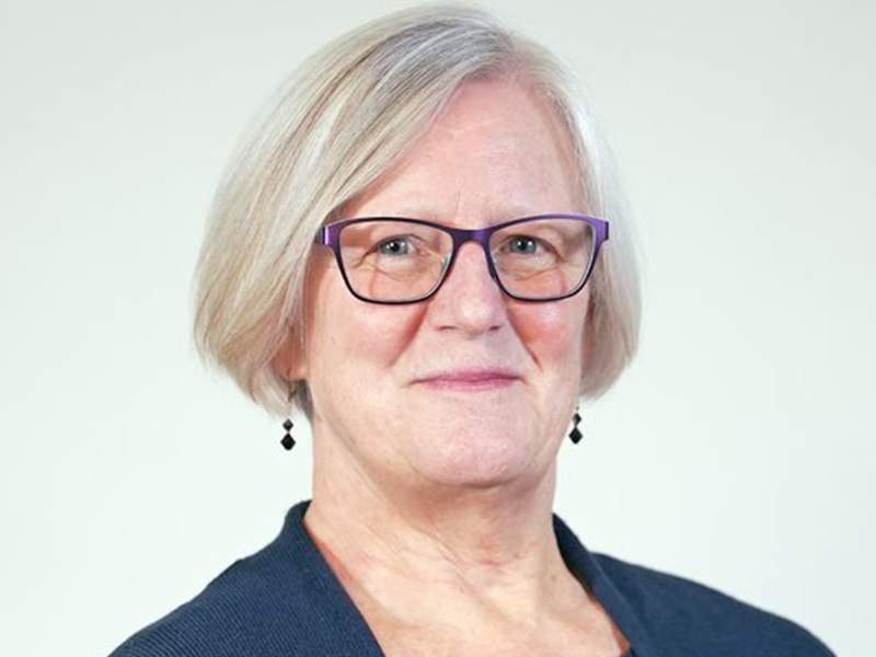 Photo of woman with light blonde hair wearing a black blouse