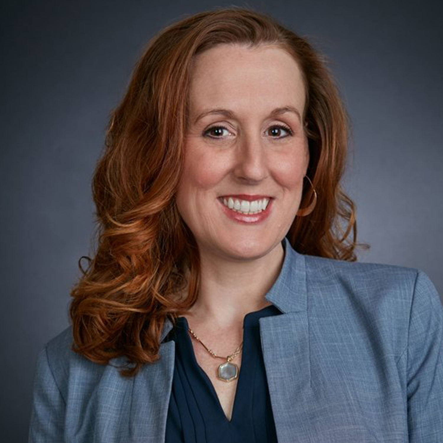 headshot of Jenn Doughty in a gray blazer