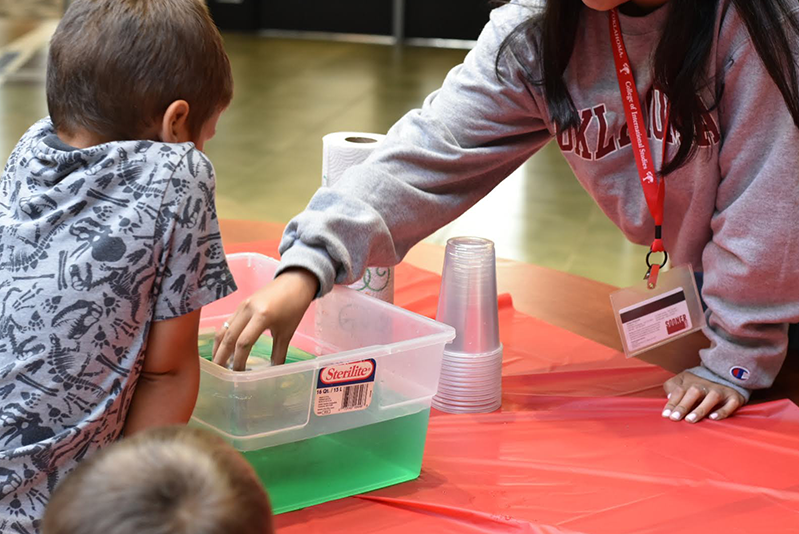 OU Student showing a child how to do a science project