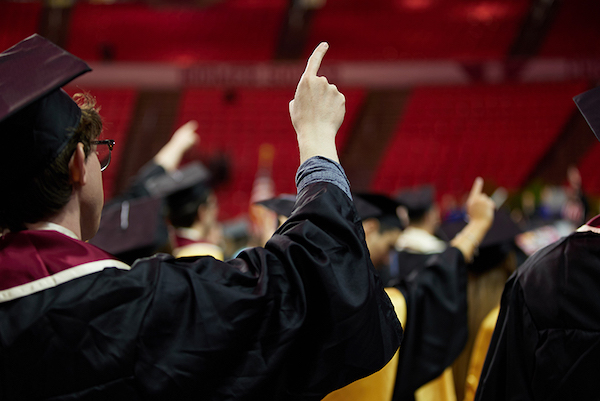 Graduating student with their finger in the air