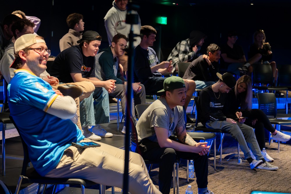 People watching an esports event in the Black Box Theater in Cross Village A. 