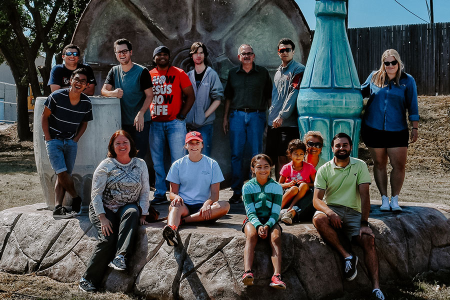 Students gathered for a photo, standing on rocks.