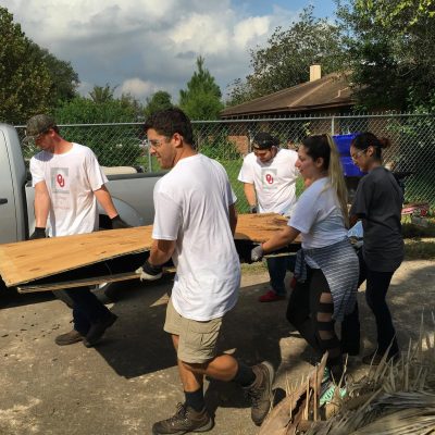 Volunteers carrying building supplies.