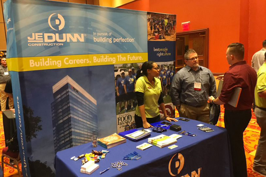 People speaking at a table during a career fair.