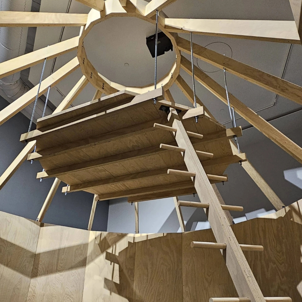 Wooden structures, including a ladder, hanging from the ceiling.