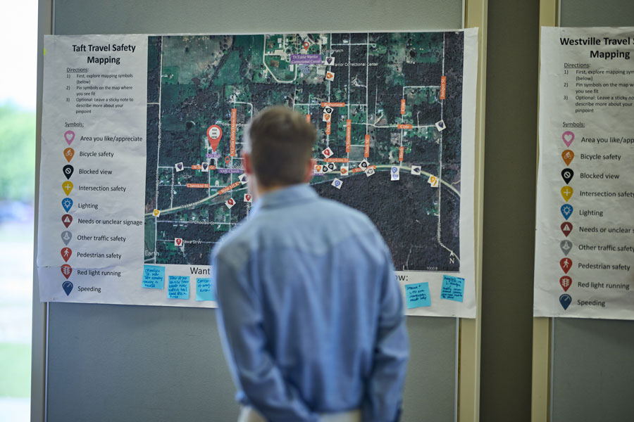 The silhouette of a man reading a travel safety map hung on a wall.