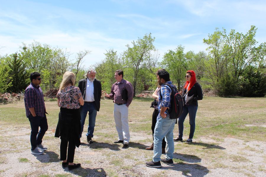 The IQC team meets in Comanche, Oklahoma having a discussion in open green space area.