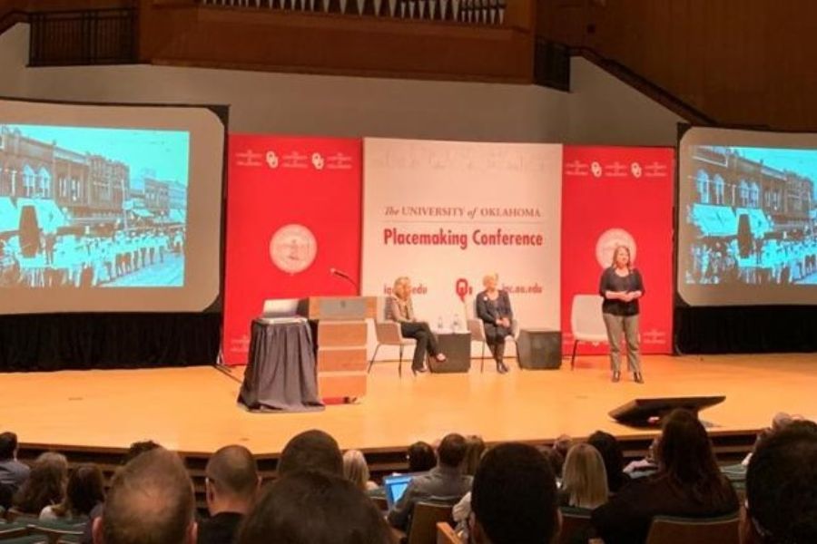  Picture from the crowd of the stage at the placemaking conference while presenters are on stage.
