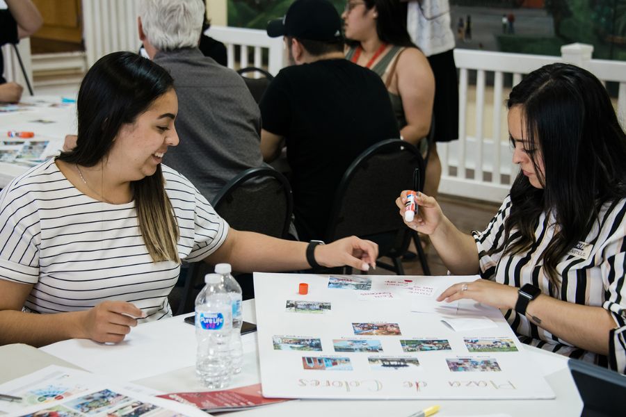 Two individuals engaging with community engagement materials at an outreach event