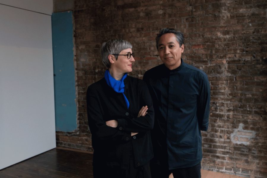 Petra Bachmaier and Sean Gallero standing against a brick wall