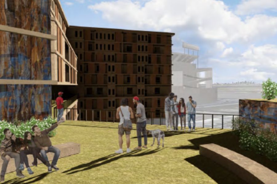 People standing and sitting on rooftop terrace near brick building