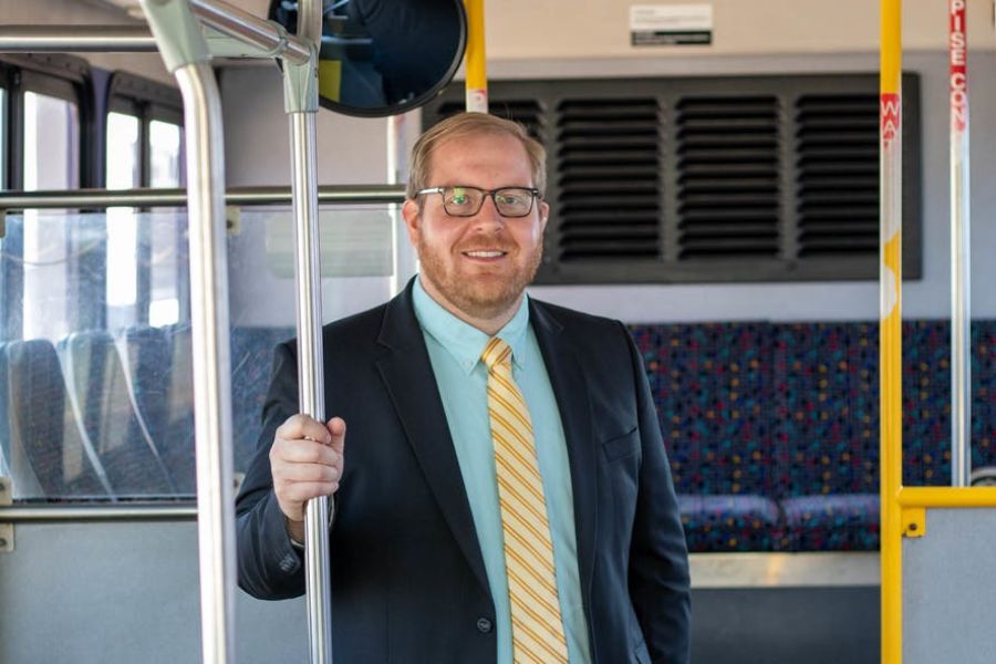 Picture of Taylor Johnson inside a bus holding on to the rail. 