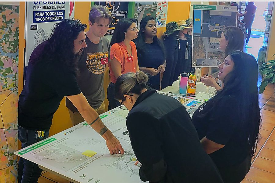 Urban Design students engaging with Tulsa community members around a table with designs and plans. 