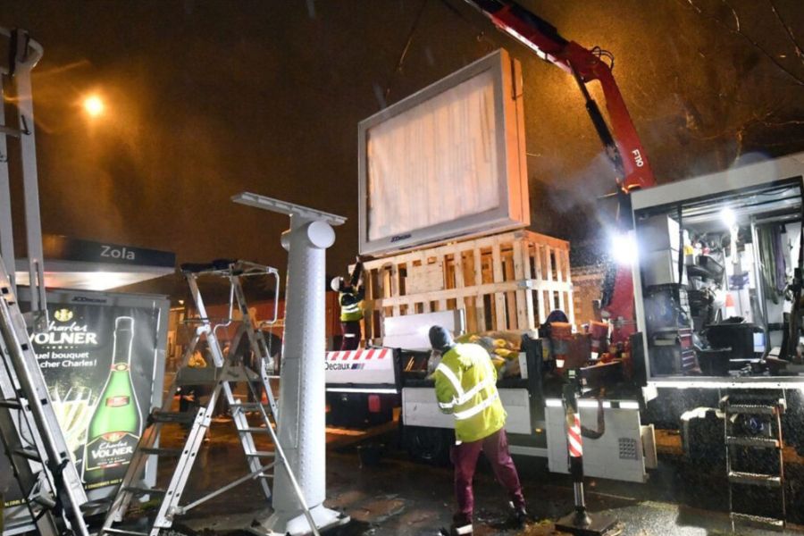 A digital billboard being constructed at night.