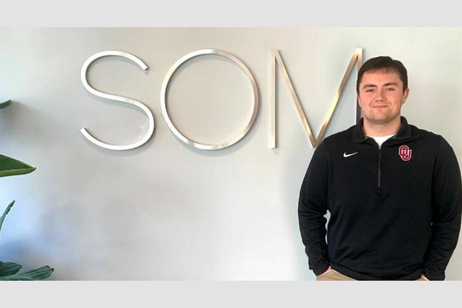 Trey London posing with the Skidmore, Owings, and Merrill logo.