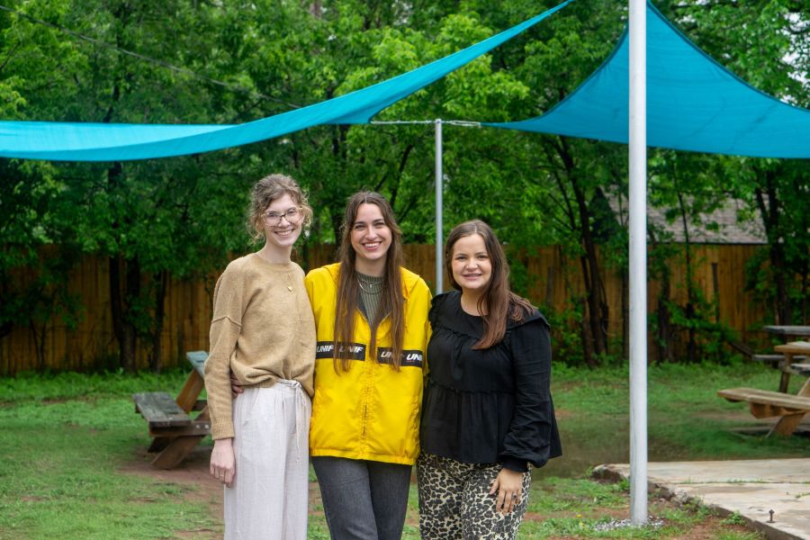 Three O U students in front of a shade pavilion.