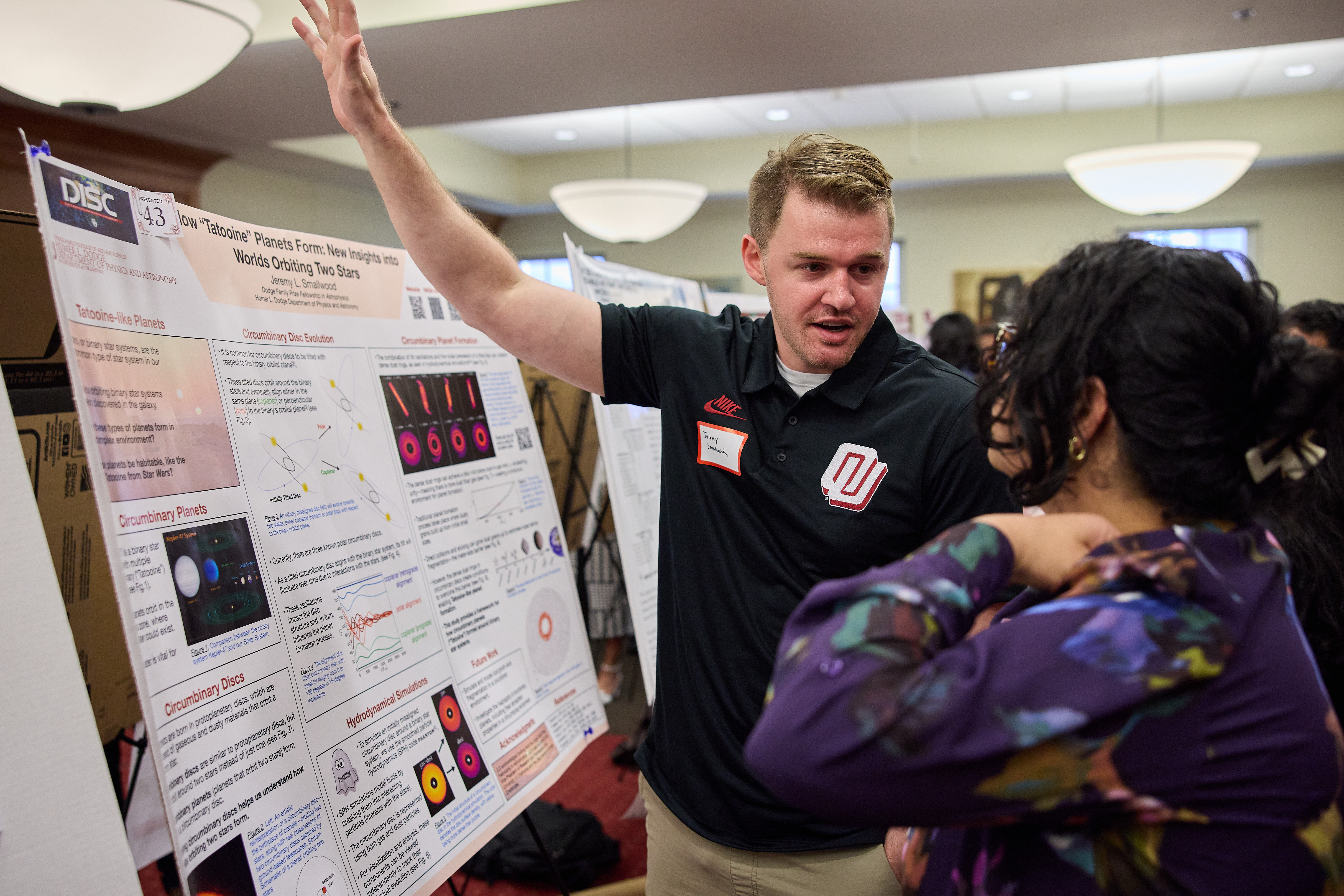 a presentor is talking about his poster in a conference