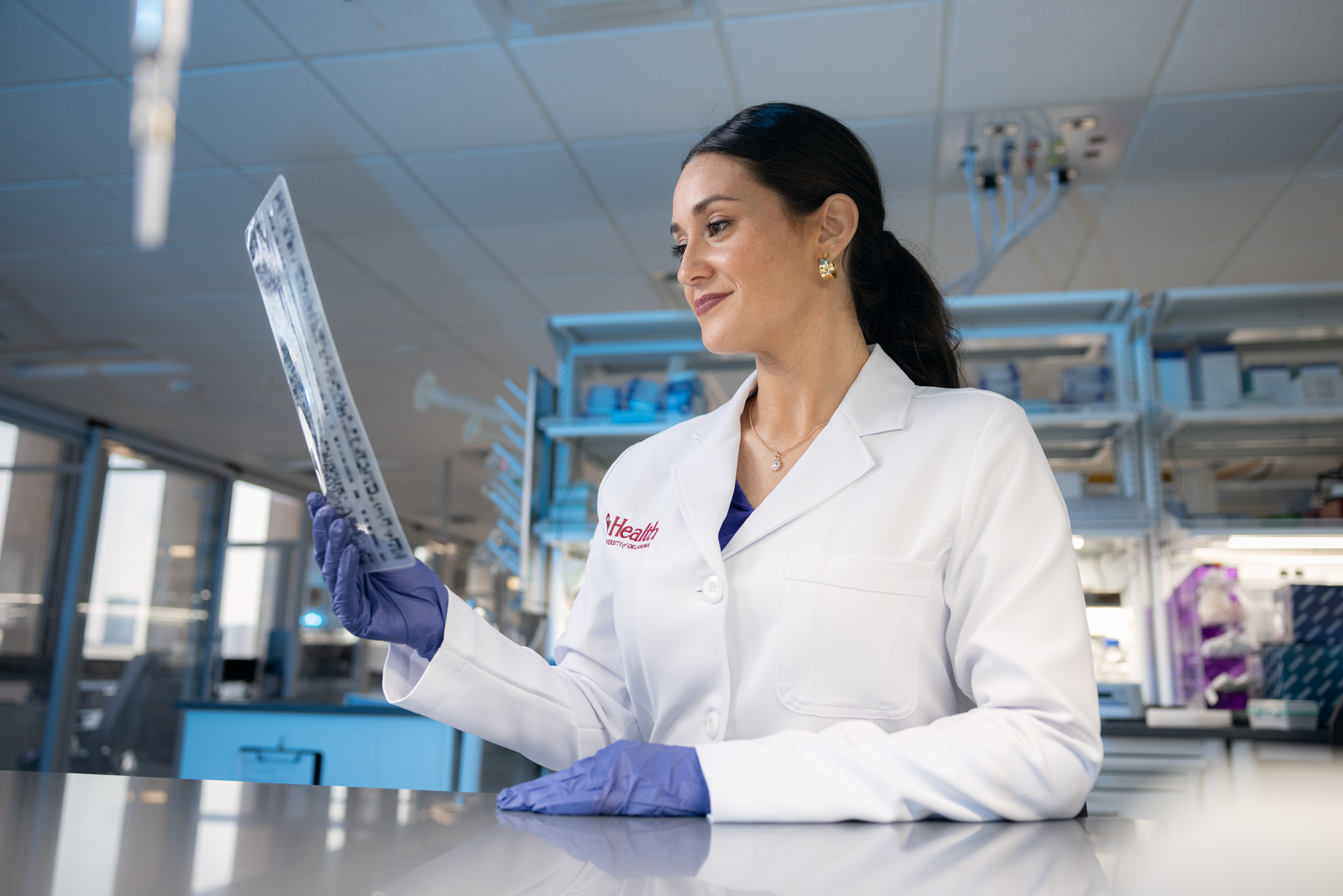 An OU Health researched in a lab, working with lab equipment.