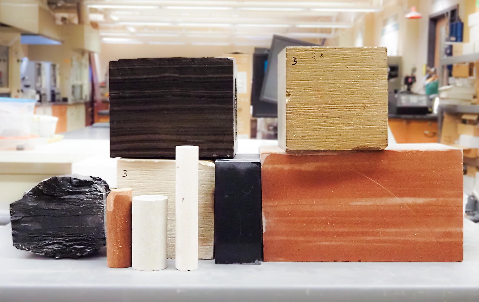 Layers of rock with mostly dark grey, with the top quarter a golden hue.