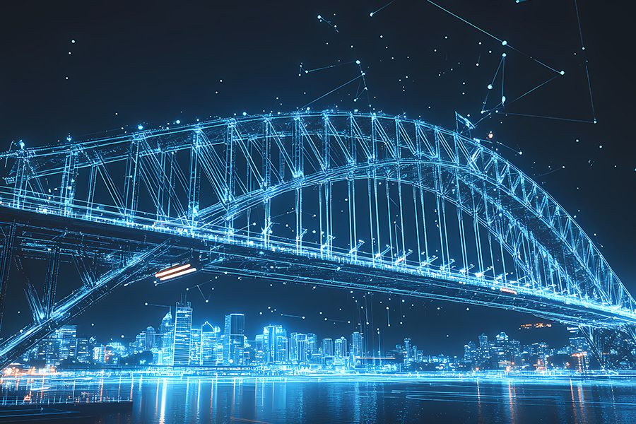 A bridge made out of light rods at night, stretched across a body of water with a large city in the background.
