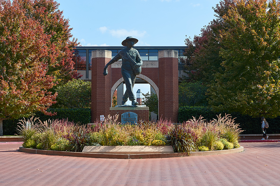 Seed sower statue from the health campus in front of a brick arch.