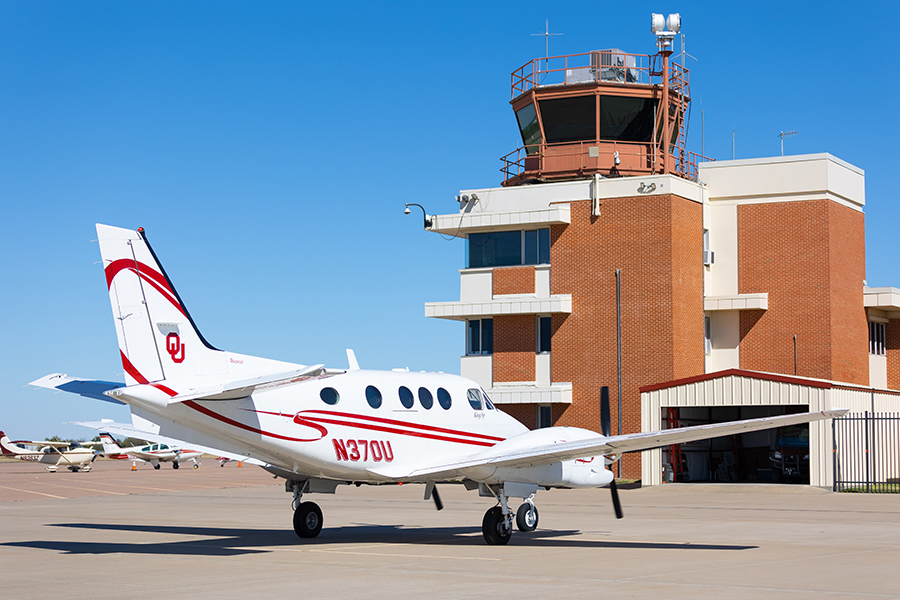 An airplane in front of the control tower at Max Westheimer Airport.