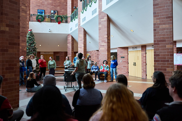 People singing in a brick auditorium.