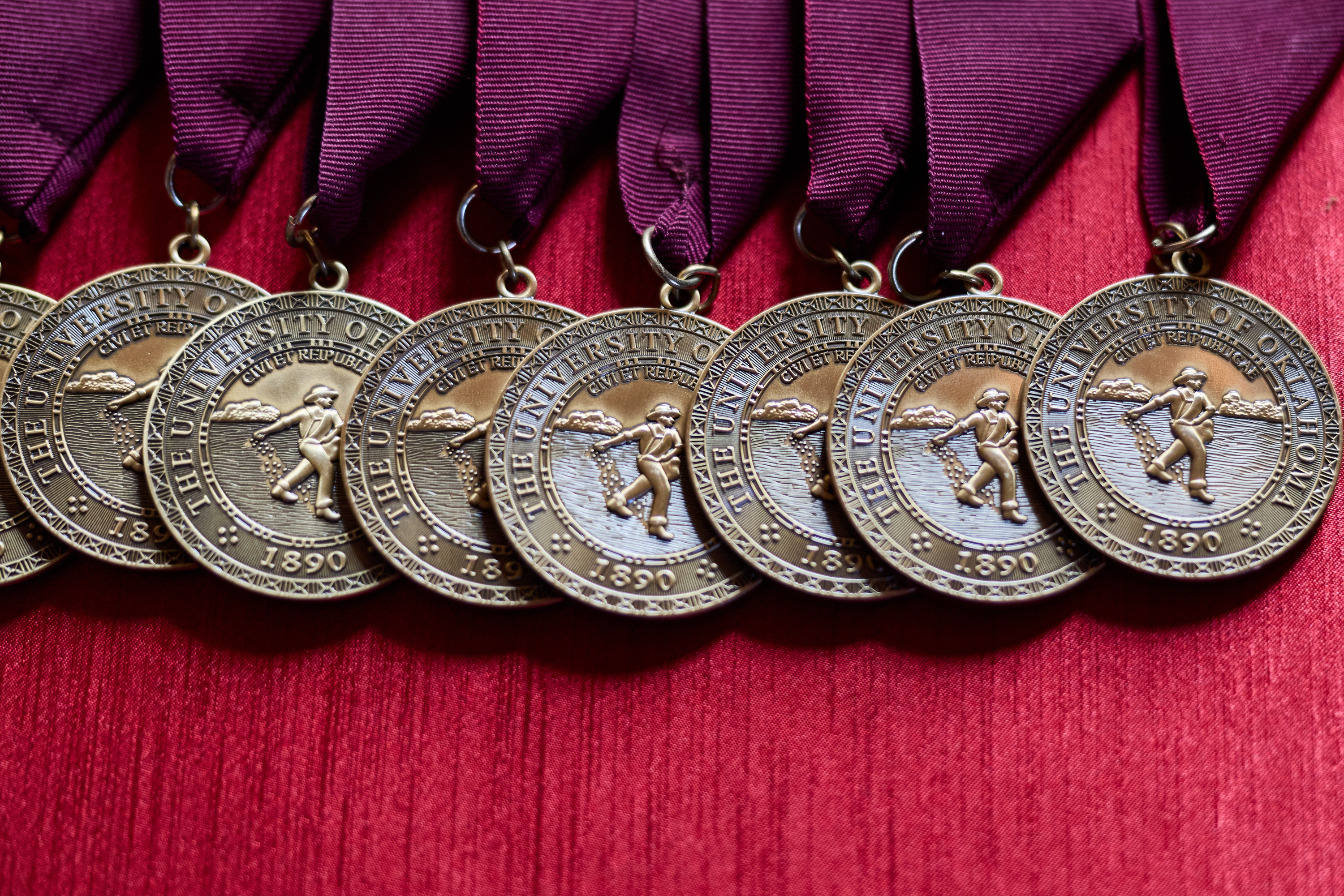 Medals lying on a red tablecloth.