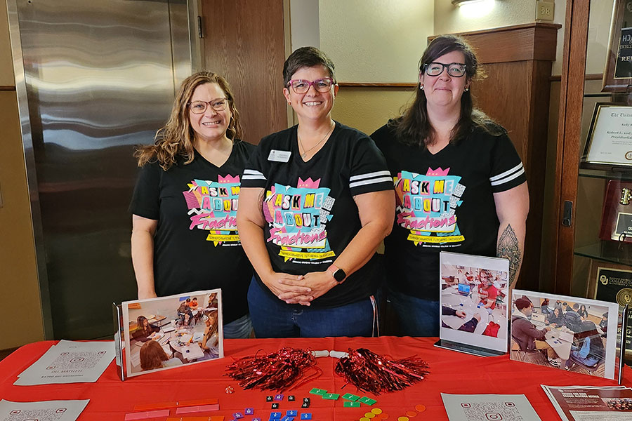 Members of the Transformational Tutoring Initiative team standing in front of a table with information about the program.