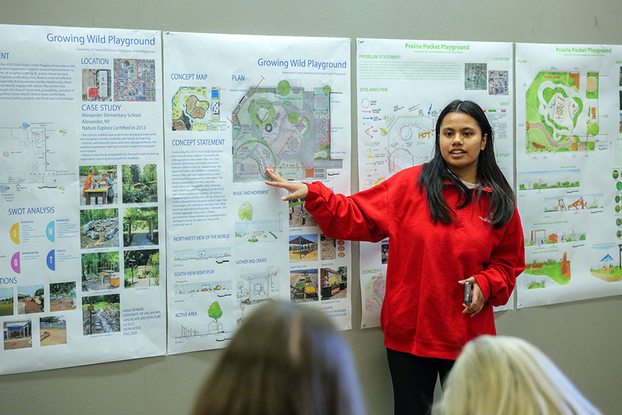 A student point to a poster presentation.
