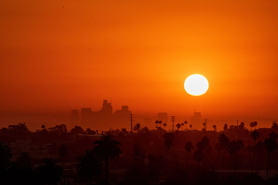 A red, hazy sky over the dark skyline of a west coast city. 