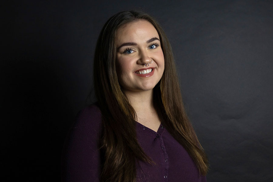 Woman smiling in front of black background.